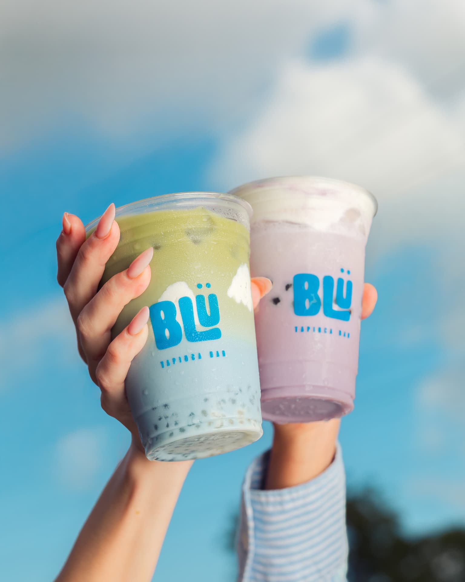 Dos bebidas de matcha y taro de BLÜ contra el cielo
