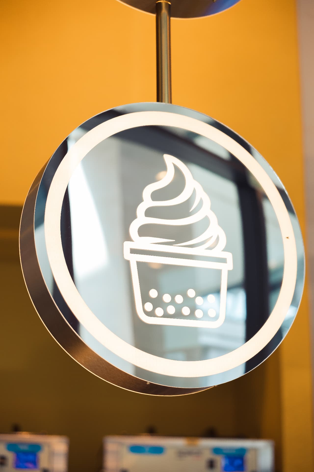 Letrero luminoso redondo de soft gelato colgado en BLÜ
