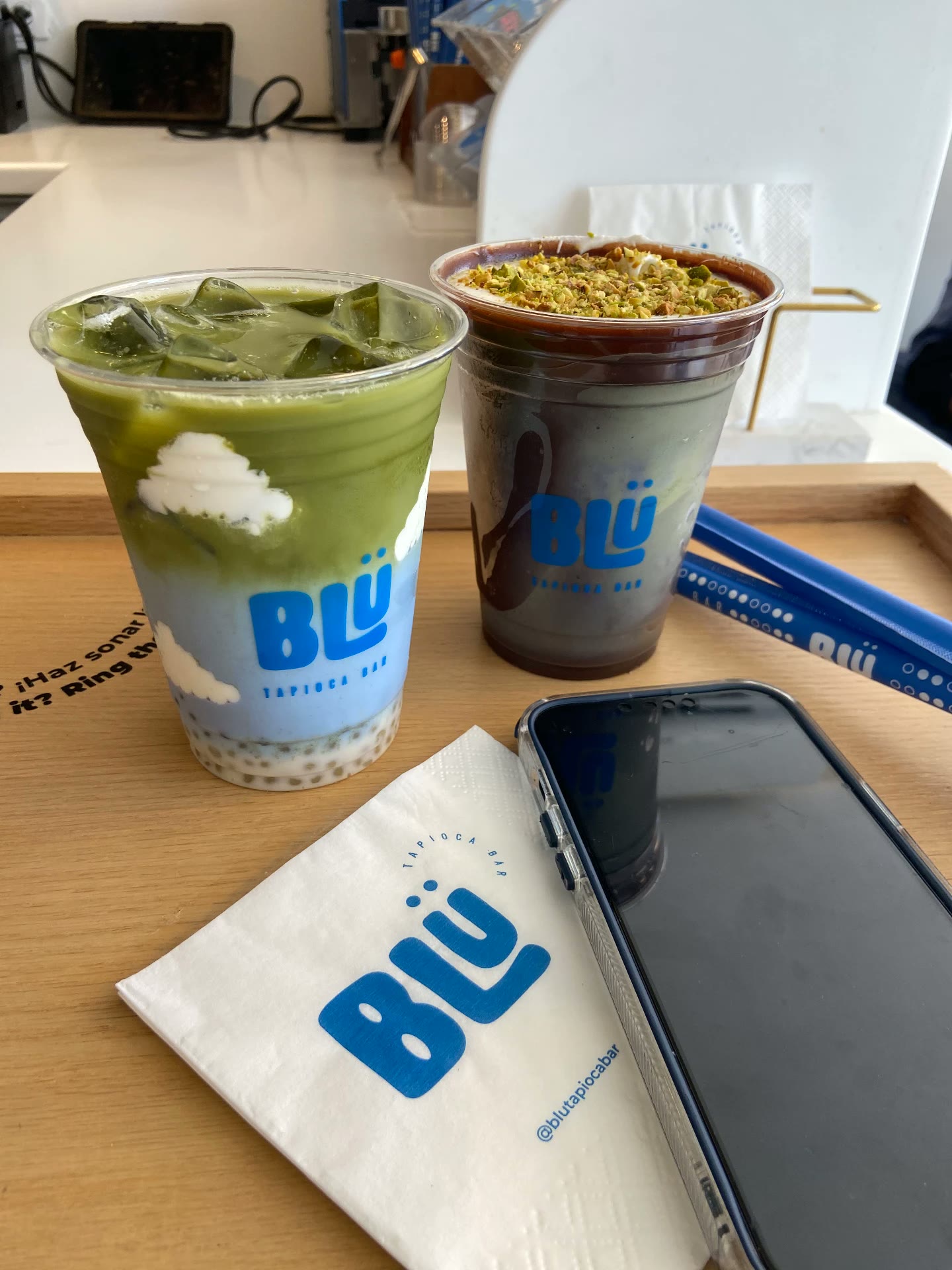 Matcha y bebida de chocolate con pistache de BLÜ en bandeja de madera