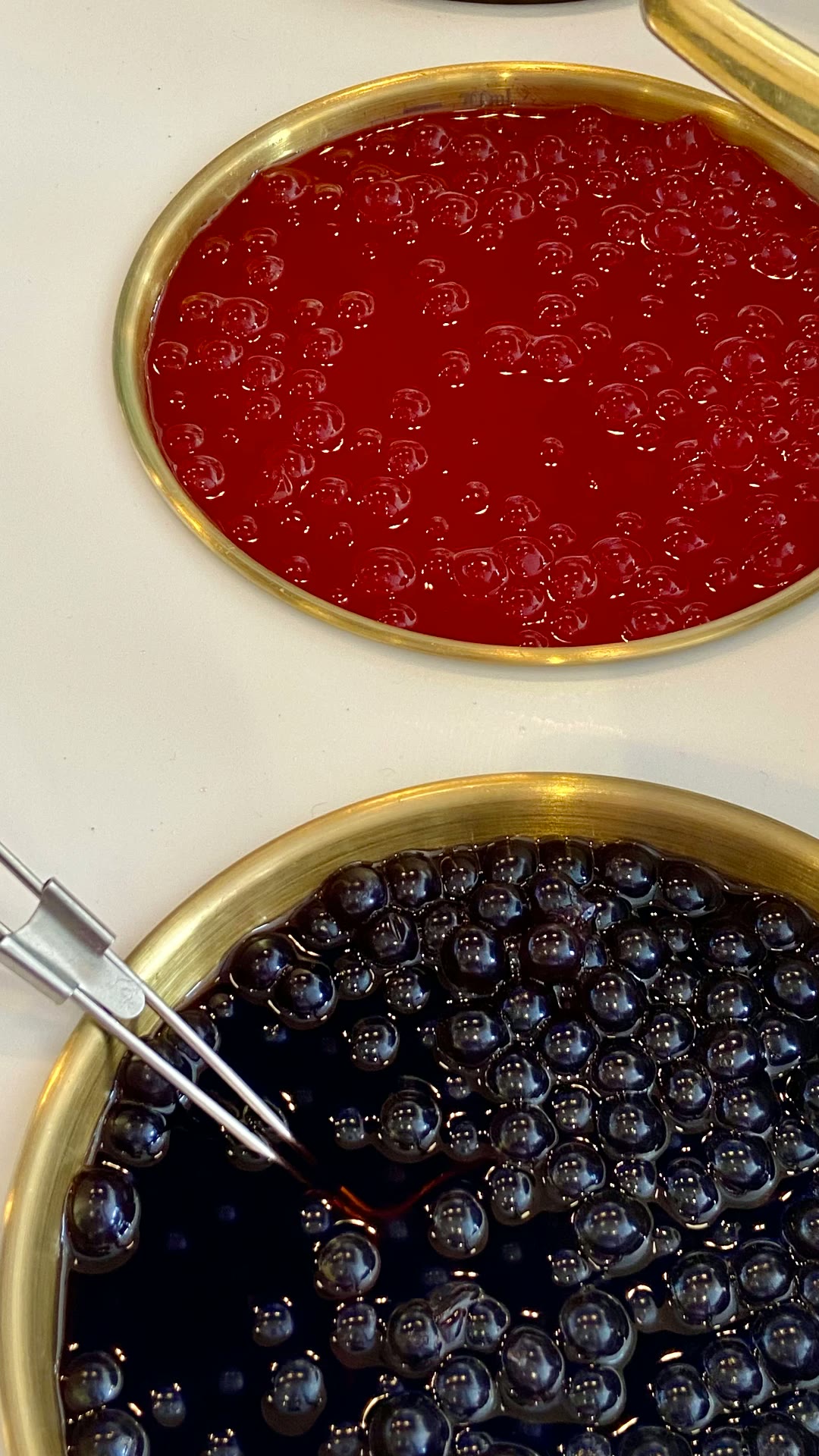 Perlas popping rojas y tapioca negra en tazones dorados de BLÜ