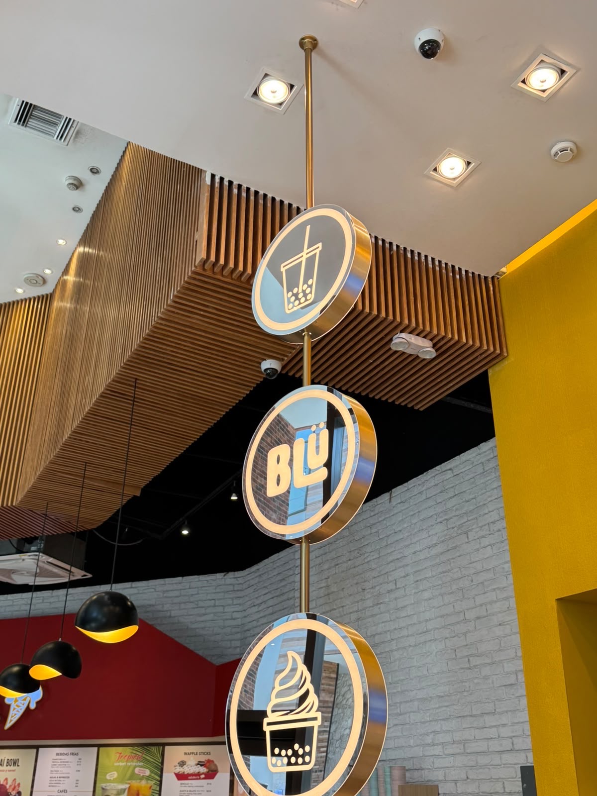 Letreros colgantes dorados de BLÜ con íconos de boba y soft gelato